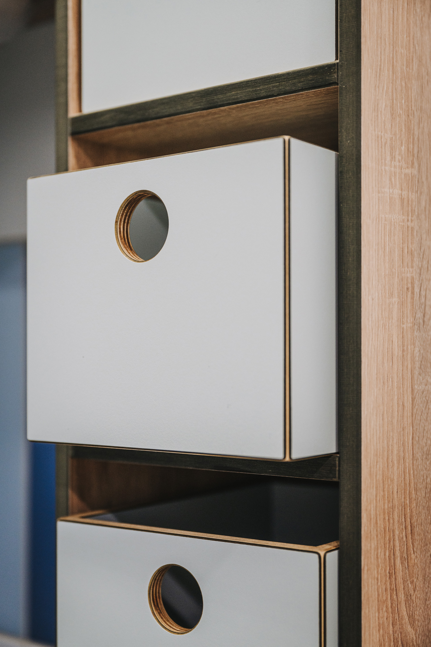 Foto: Detailaufnahme Holz Aufbewahrungsbox in Wickelregal mit weißer Beschichtung und kreisförmigem Griffloch.